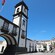 An archway of a building featuring a clock tower in the town center